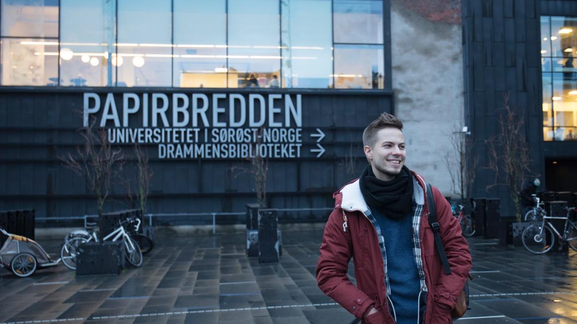 Jakov Lind foran campus Drammen hvor han snart er ferdig utdannet sykepleier. 